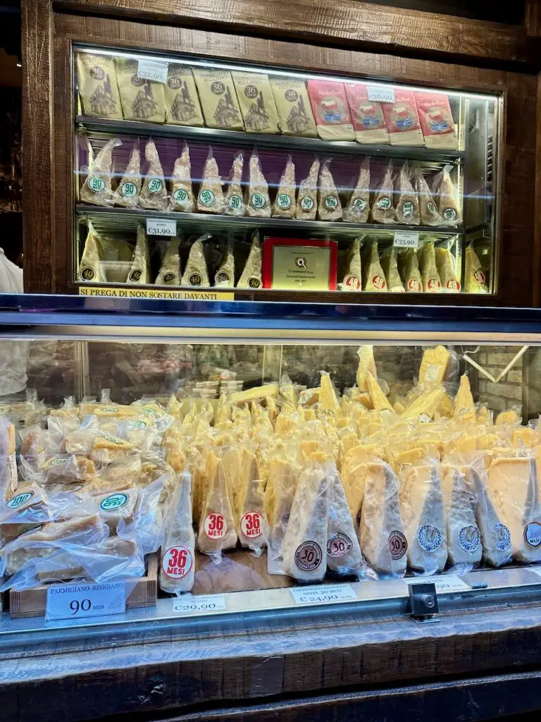 Various cheeses in the window of a market in Bologna.