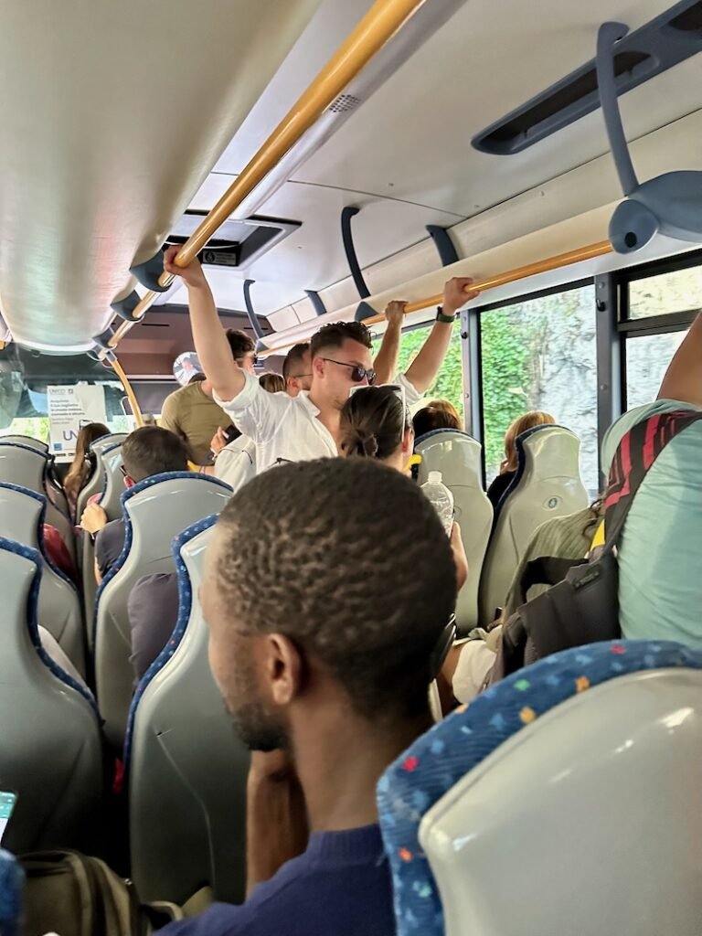 Crowded SITA bus from Positano, with passengers standing during the ride toward Sorrento on the Amalfi Coast.