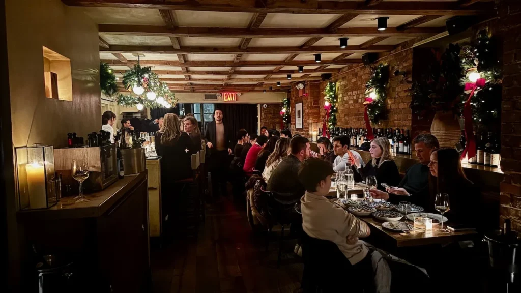 Interior dining room at Rezdôra in New York City with warm lighting and brick walls