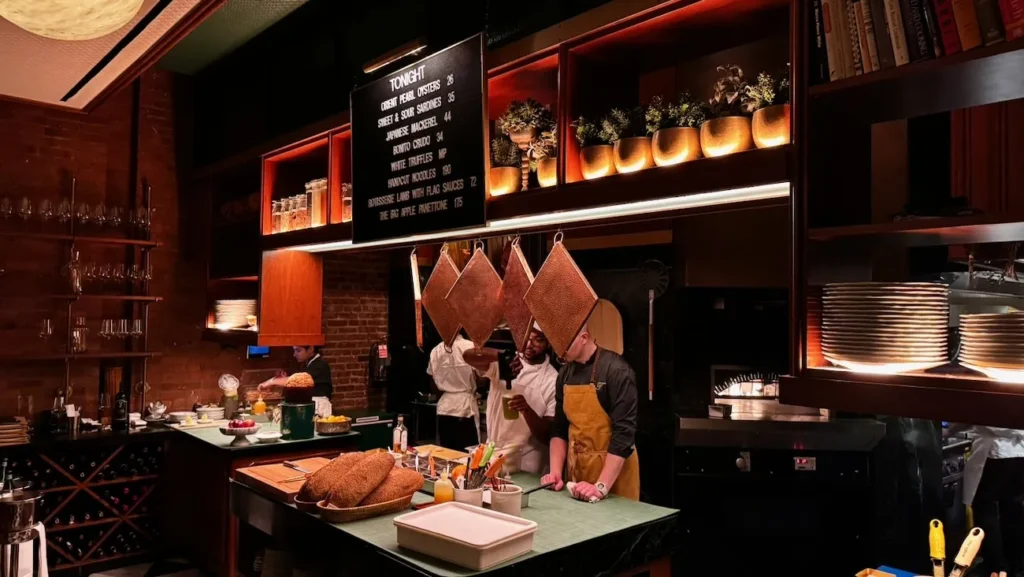Open kitchen at Torrisi Restaurant & Bar in New York City, with chefs preparing dishes in the Nolita dining room