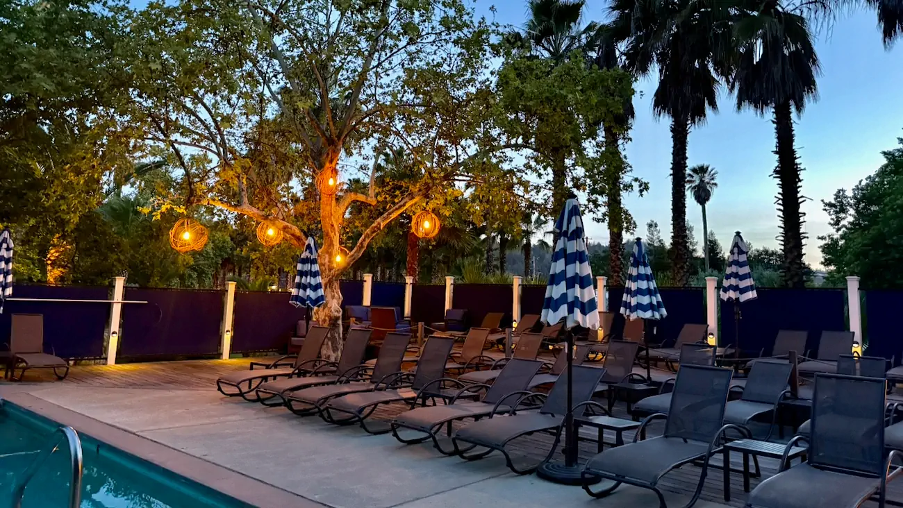 Lounge chairs surrounding the mineral pool at Indian Springs Calistoga in the evening.