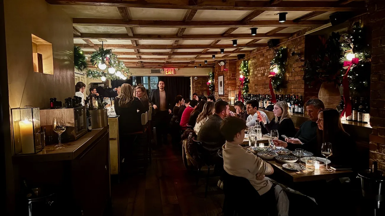 Interior dining room at Rezdôra in New York City with warm lighting and brick walls