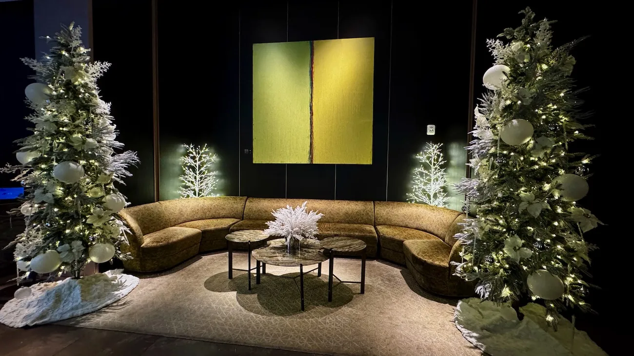 Holiday-decorated lounge seating area with illuminated Christmas trees at The Ritz-Carlton NoMad in New York City